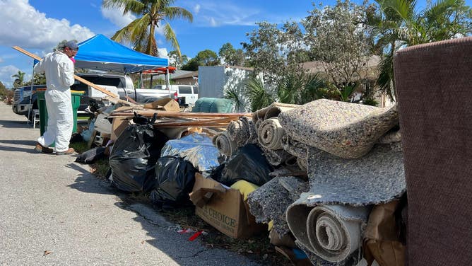 Flood-damaged items are placed along the road in Naples, Florida.