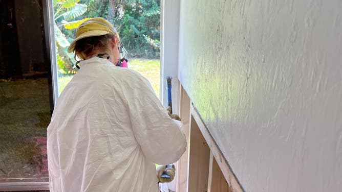 A volunteer with St. Bernard Project repairs drywall.