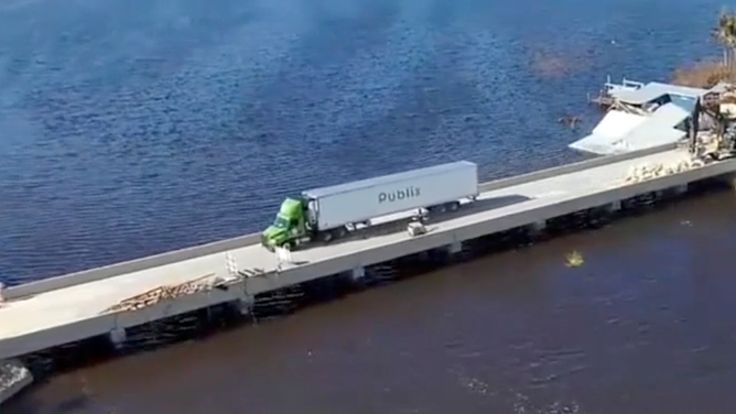 A semi-truck drives over the temporary bridge leading to Pine Island, Florida.