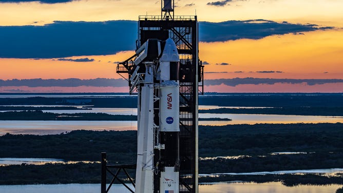 Saulė leidžiasi už SpaceX Falcon 9 raketos ir erdvėlaivio Dragon Kennedy kosmoso centre Floridoje prieš Crew-5 astronauto paleidimą.
