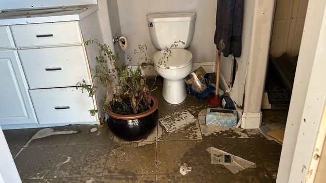 Mud and debris cover the bathroom floor after Hurricane Ian.