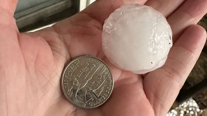 A hailstone next to a quarter for scale. Hail fell in Salado, TX on November 11, 2022.