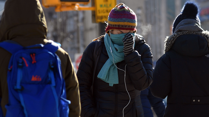FILE - People walk through the freezing cold in the Brooklyn borough of New York on January 31, 2019.