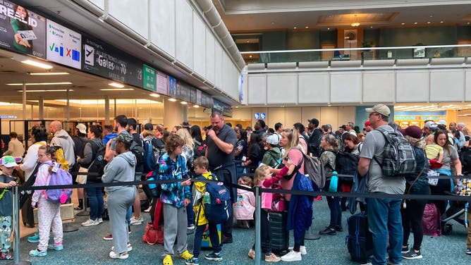 People wait in a TSA screening line at Orlando International Airport three days before Thanksgiving in Orlando, Florida.