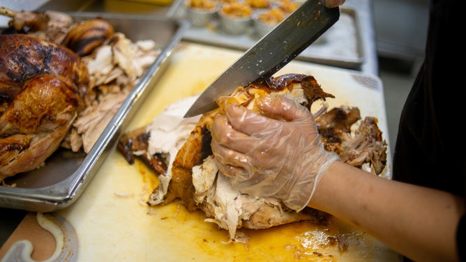 A chef carves a turkey for Thanksgiving dinner.