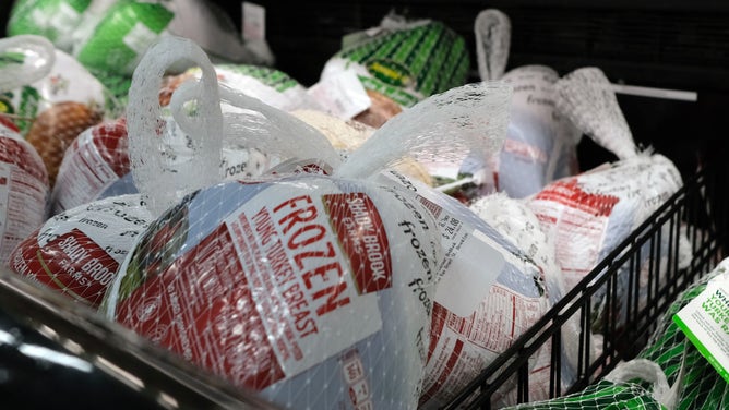 Frozen turkeys are displayed for sale inside a grocery store.