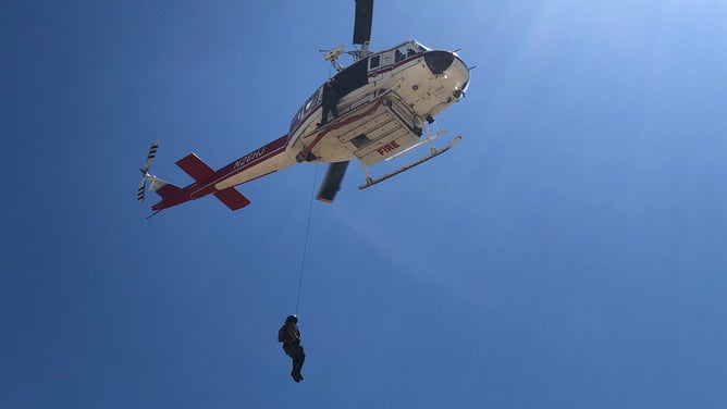 A helicopter and crew during a hoist extraction.