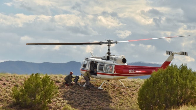 Crew members and a helicopter.