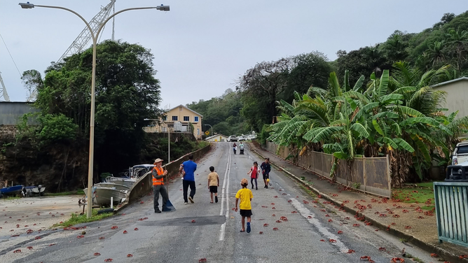 FILE - CHRISTMAS ISLAND - NOVEMBER 8: In this handout image provided by Parks Australia, members of the public and Parks Australia staff rack away thousands of red crabs off a road on November 8, 2021 in Christmas Island. The annual migration of red crabs begins with first rains of the wet season on Christmas Island, usually around October or November. Millions of the red crabs make their way across the island to the ocean to mate and spawn.