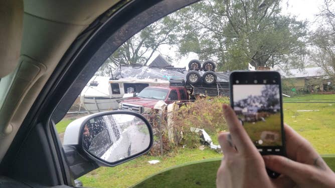 Photo of an RV flipped into a red truck after a tornado ripped through New Iberia, Louisiana.