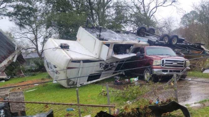 Photo of an RV flipped into a red truck after a tornado ripped through New Iberia, Louisiana.