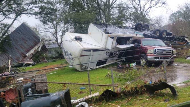 Photo of an RV flipped into a red truck after a tornado ripped through New Iberia, Louisiana.