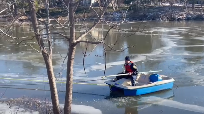 Firefighters on shore pull the paddle boat back ashore.