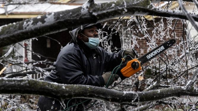 FILE - Edward Caldwell works to clear a downed tree at his moms house on February 3, 2022 in Memphis, Tennessee.