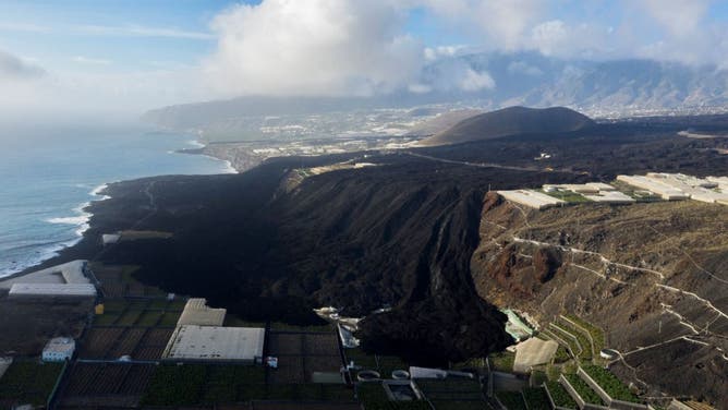 An aerial picture taken on September 12, 2022 shows streams of lava that cover an agricultural area near Puerto de Naos, on the Canary island of La Palma, one year after the eruption of the Tajogaite volcano, in the Cumbre Vieja mountain range. - For many on the tiny isle, life remains difficult and the future uncertain since the eruption of the Tajogaite volcano, in the Cumbre Vieja mountain range, which will mark its first anniversary on September 19, 2022. (Photo by Juan MAZA CALLEJA / AFP) (Photo by JUAN MAZA CALLEJA/AFP via Getty Images)