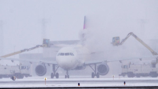 FILE - A Delta Airlines jet is de-iced at Minneapolis-St. Paul International Airport near St. Paul, Minn. on Tuesday, Nov. 29, 2022.