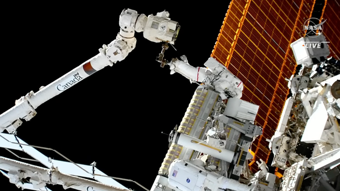 NASA astronaut Josh Cassada attached to the space station CanadaArm2 with a rollout solar array. Cassada and NASA Astronaut Frank Rubio are spacewalking on Dec. 3, 2022 to installed two new solar arrays.