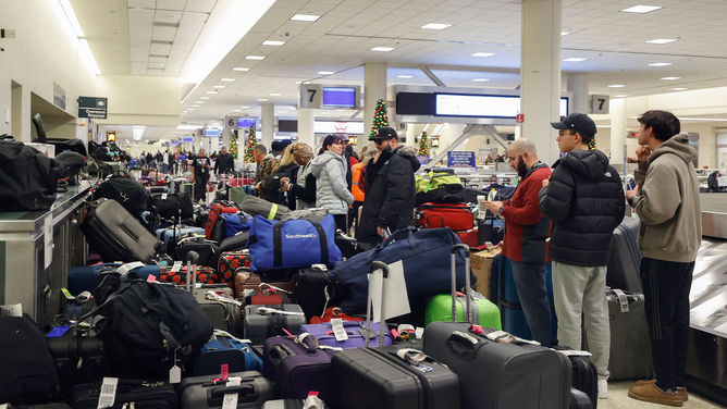 Stranded Southwest Airlines passengers looks for their luggage in the baggage claim area at Chicago Midway International Airport in Chicago, Illinois, on December 28, 2022. - The perfect storm of fierce snow squalls, howling wind and sub-zero temperatures forced the cancellation of thousands of flights in recent days, including around 5,900 on Tuesday and Wednesday, according to tracking site FlightAware.com. Most of the cancellations on December 27-28 were at Southwest Airlines, which pulled more than 60 percent of its flights due to cascading logistics issues.