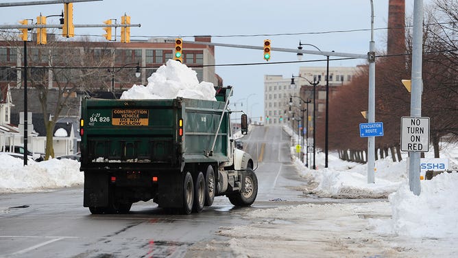 A dump truck carrying snow after a buffalo blizzard.