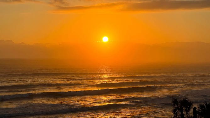 FILE - The sun rises over Daytona Beach Shores, Florida.