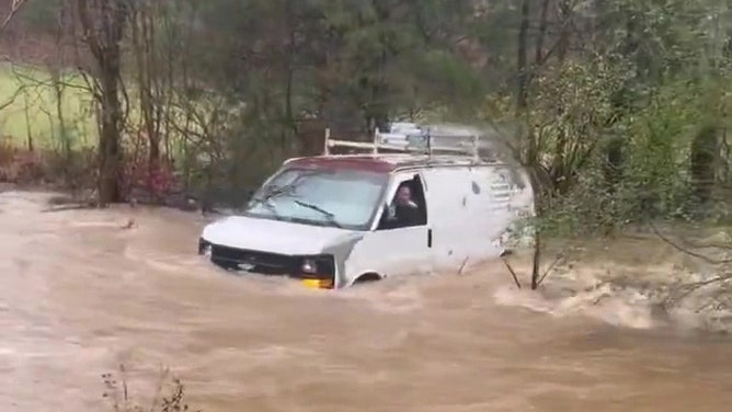 Van swept away by floodwaters
