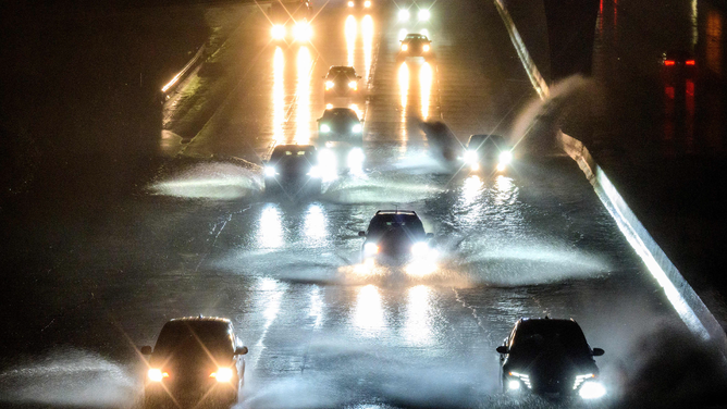 Drivers barrel into standing water on Interstate 101 in San Francisco, California on January 4, 2023. - A bomb cyclone smashed into California on January 4, 2023, bringing powerful winds and torrential rain that was expected to cause flooding in areas already saturated by consecutive storms.