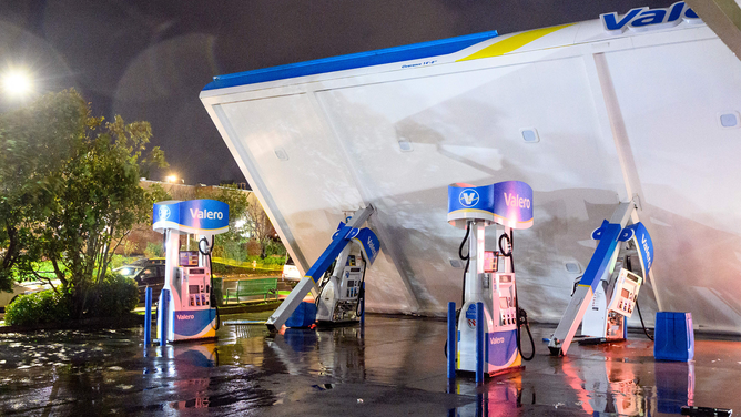 A damaged Valero gas station creaks in the wind during a massive "bomb cyclone" rain storm in South San Francisco, California on January 4, 2023. - A bomb cyclone smashed into California on January 4, 2023, bringing powerful winds and torrential rain that was expected to cause flooding in areas already saturated by consecutive storms.