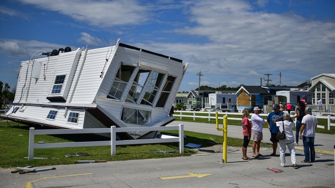 Residents stand next to upside down mobile home in the Emerald Isle RV Park after a tornado touched down during Hurricane Dorian in Emerald Isle, North Carolina, U.S., on Sept. 6, 2019.