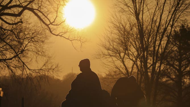 Silhouettes of people are seen during sunset at Lincoln Memorial in Washington D.C. on December 29, 2022.