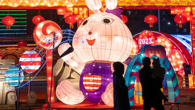 People walk by an illuminated rabbit lantern during a lantern show at a tourist attraction ahead of the Chinese New Year, the Year of the Rabbit, on January 19, 2023 in Yuncheng, Shanxi Province of China.