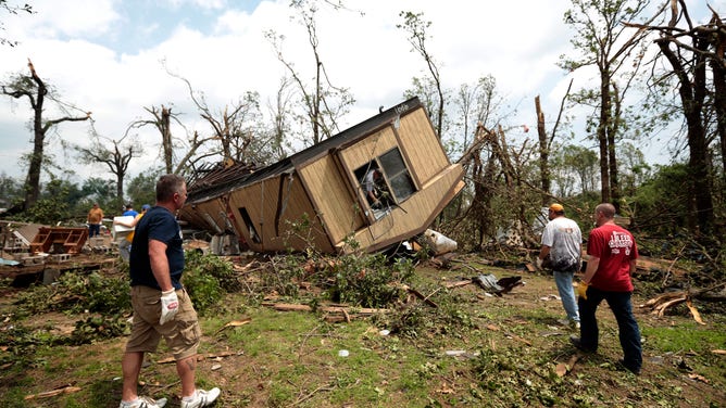 Volunteers help clean out Jean McAdams' mobile home after it was overturned by a tornado May 20, 2013 near Shawnee, Oklahoma. 