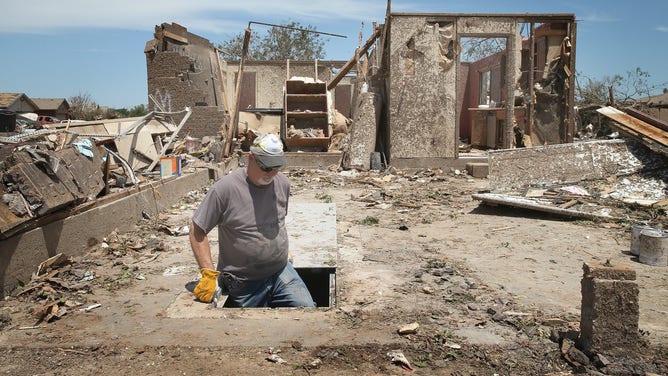 Man emerges from a storm shelter in a home that was destroyed by a tornado on May 22, 2013 in Moore, Oklahoma. 