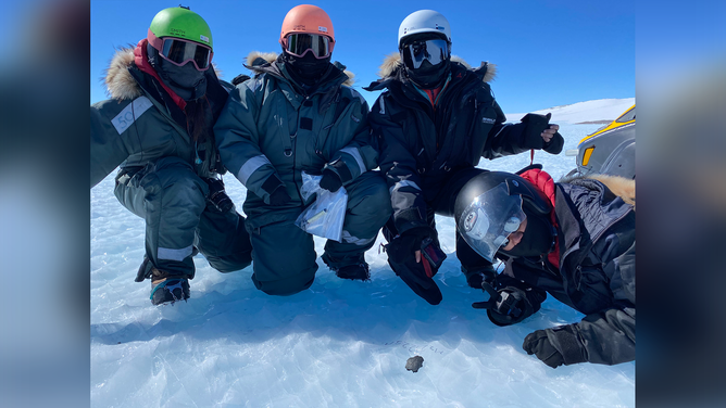 Researchers with one of the meteorites discovered in Antarctica. 