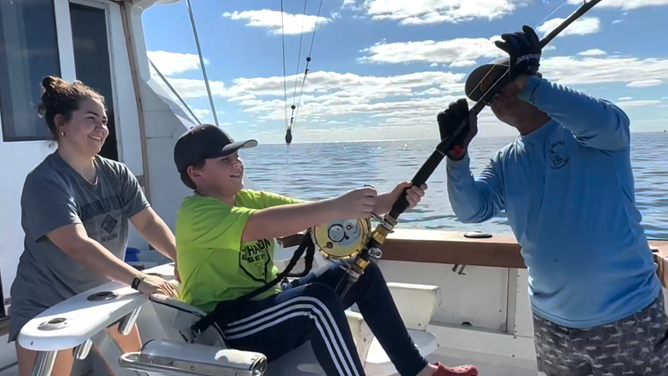 Campbell (center) attempting to reel in his catch.