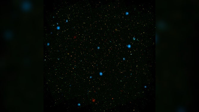 The blue dots in this field of galaxies, known as the COSMOS field, show galaxies that contain supermassive black holes emitting high-energy X-rays. The black holes were detected by NASA's Nuclear Spectroscopic Array, or NuSTAR, which spotted 32 such black holes in this field and has observed hundreds across the whole sky.
