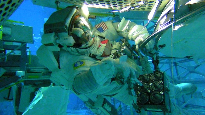 In the Neutral Buoyancy Lab at Johnson Space Center, NASA astronaut Victor Glover tests collection methods for ISS External Microorganisms, which examines microbes released from the space station to help limit contamination on future exploration missions.