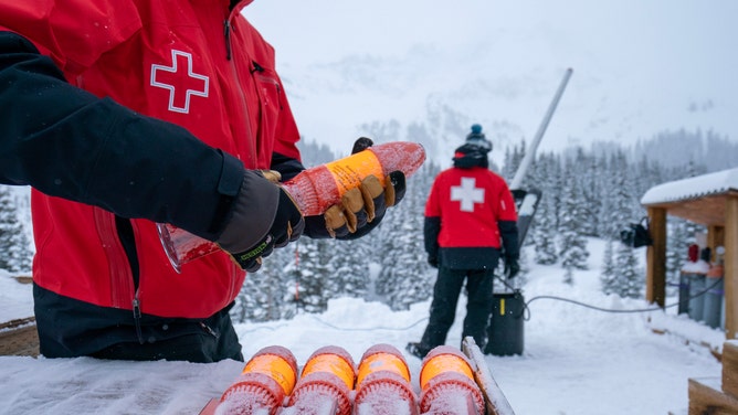 Members of ski patrol launching explosives into the mountain.