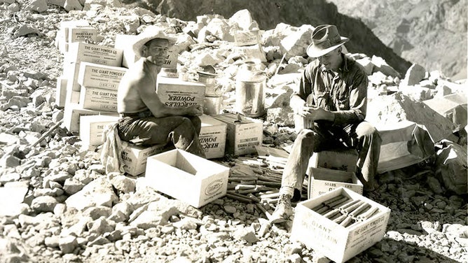 "Powder-monkeys" load dynamite cartridges with electric primers at isolated points. August 15, 1932.