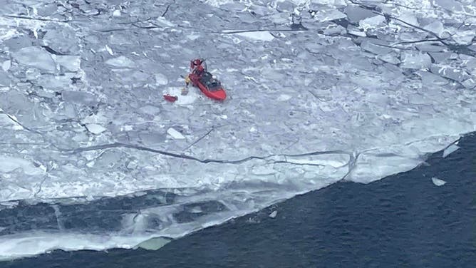 A U.S. Coast Guard airboat rescues a group of people stranded on an ice floe.