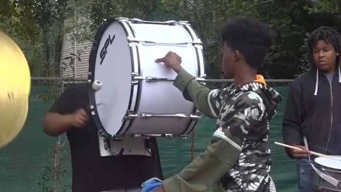 Black students play music outdoors.
