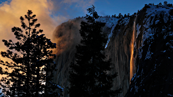 FILE - Horsetail Falls lights up from the setting sun against El Capitan in Yosemite National Park in Yosemite, Calif., on Monday, February 18, 2019. The popular lightshow is known as Firefall and happens in the later weeks of February when the setting sun hits the waterfall caused by runoff after snowfall in the area. The phenomenon is expected to be visible through the week.