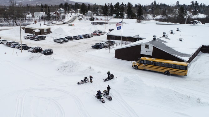 Students arrive to class on snowmobiles at Forest Hills Consolidated School in Jackman, ME on Feb. 28, 2020. 