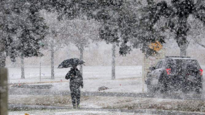 A man walks on the snow covered sidewalk while the snow fall at Norman, Oklahoma, USA. 24 January 2023.