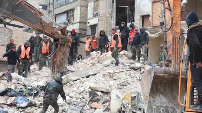 Syrian rescue teams look for survivors under the rubble after a 7.8 magnitude earthquake in the government-controlled central Syrian city of Hama on February 6, 2023. - The earthquake hit Turkey and Syria early on February 6, killing hundreds of people as they slept, levelling buildings and sending tremors that were felt as far away as the island of Cyprus, Egypt and Iraq.