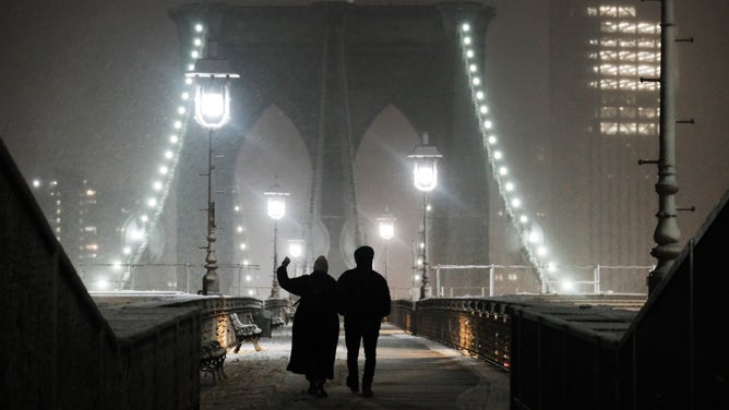 NEW YORK, NEW YORK - FEBRUARY 27: People walk across the Brooklyn Bridge during a storm on February 27, 2023 in New York City. Parts of northern New York City could see up to five inches of snow by morning in what would be the first real snowfall of the winter.