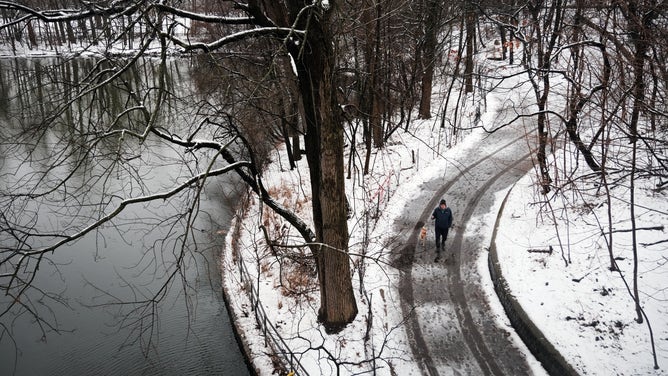 NEW YORK, NEW YORK - FEBRUARY 28: People walk through Brooklyn's Prospect Park on a snowy morning over on February 28, 2023 in New York City. New York City and much of the Northeast received overnight snow, sleet and rain in what is first real snowfall of the winter for many communities.