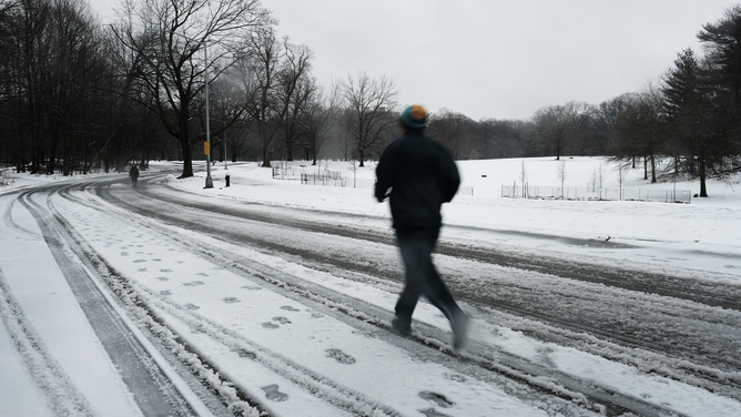 People run through Brooklyn's Prospect Park on a snowy morning over on February 28, 2023 in New York City. New York City and much of the Northeast received overnight snow, sleet and rain in what is first real snowfall of the winter for many communities.