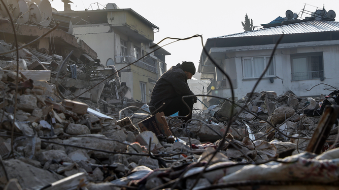 A man sits on top of a collapsed building on February 13, 2023 in Hatay, Turkey. A 7.8-magnitude earthquake hit near Gaziantep, Turkey, in the early hours of Monday, followed by another 7.5-magnitude tremor just after midday. The quakes caused widespread destruction in southern Turkey and northern Syria and were felt in nearby countries.
