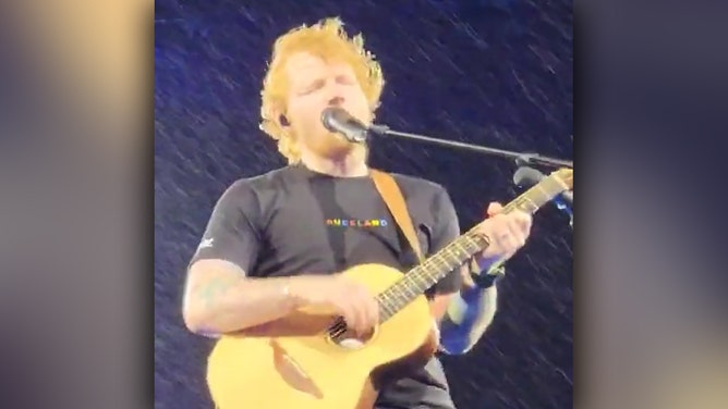 Ed Sheeran performs in rain