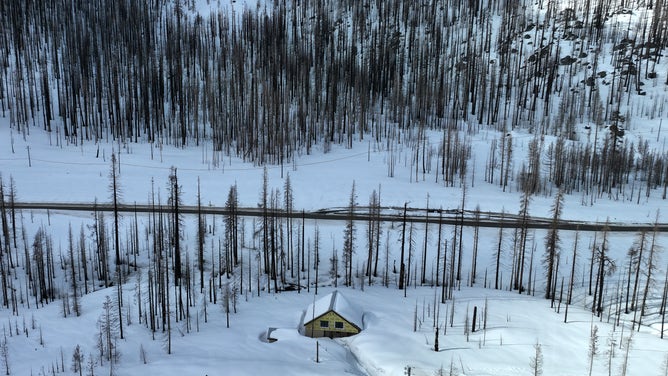 TWIN BRIDGES, CALIFORNIA - MARCH 20: In an aerial view, a home is seen buried in snow on March 20, 2023 in Twin Bridges, California. The Lake Tahoe region is preparing for more snow in the coming days after seeing near record levels of snow so far this season. California continues to be impacted by atmospheric river events that are pummeling the state with heavy rains, high winds and snow.
